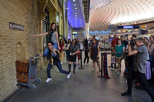 Tourists having their photo taken on platform 9 and three quarters at Kings Cross station