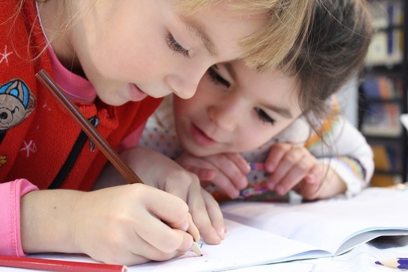Two children working on a written task Two children working on a written task