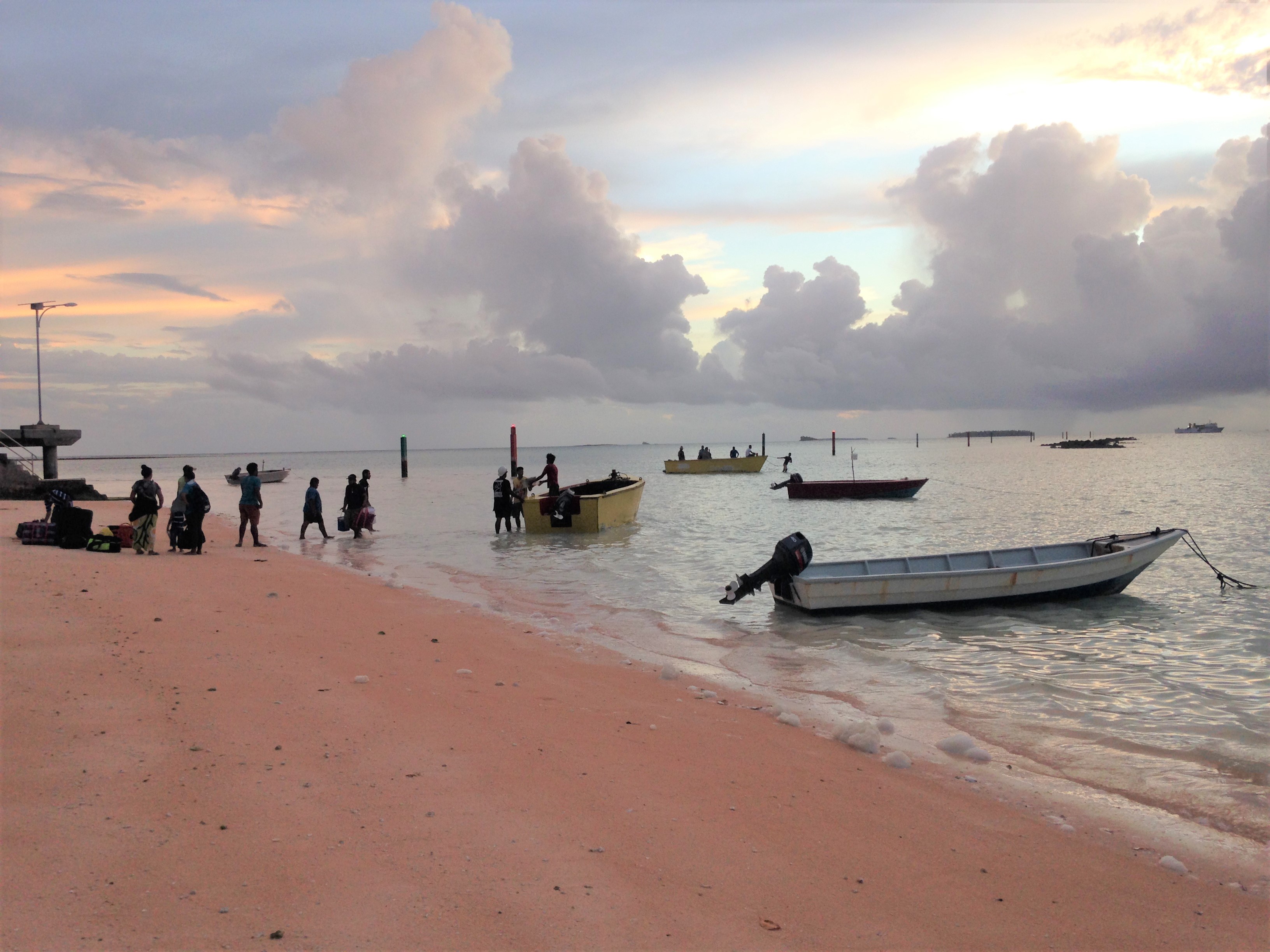 Coastline of Tuvalu showing residents with boats on the shore Coastline of Tuvalu showing residents with boats on the shore