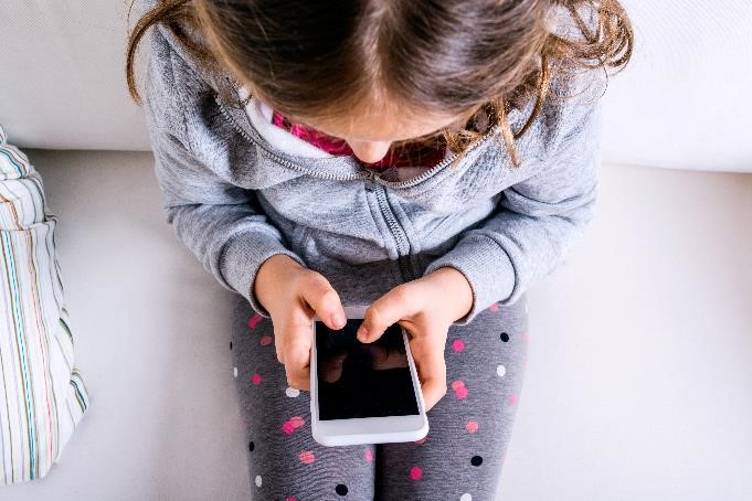 Child sitting down and using phone