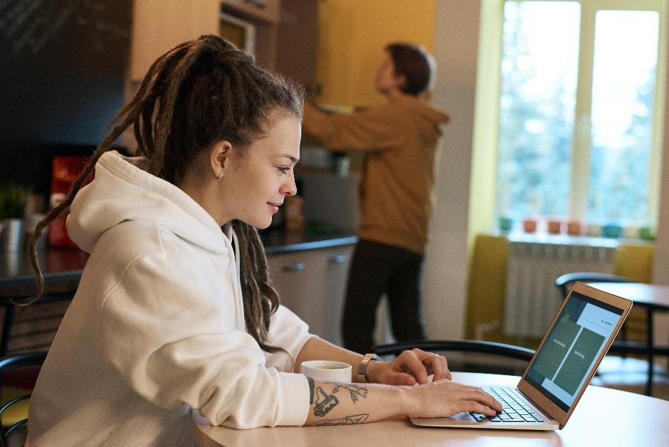 A woman working at a laptop in home surroundings.