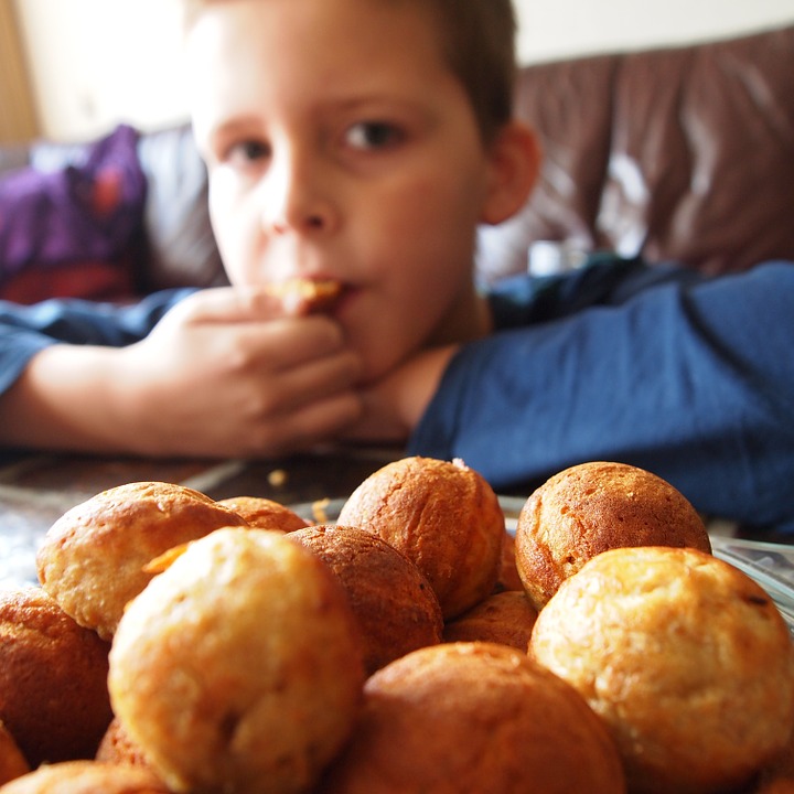 Boy eating a cake with a guilty expression on his face.