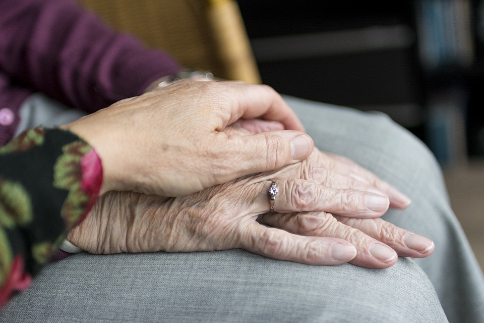 Hands - a younger one on top of an older one suggesting care-giving. 