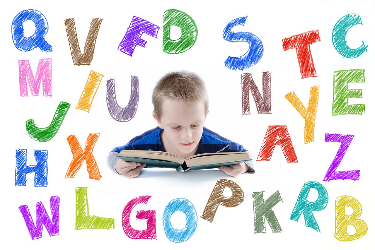 A child reading a book surrounded by graphics of colourful letters of the alphabet