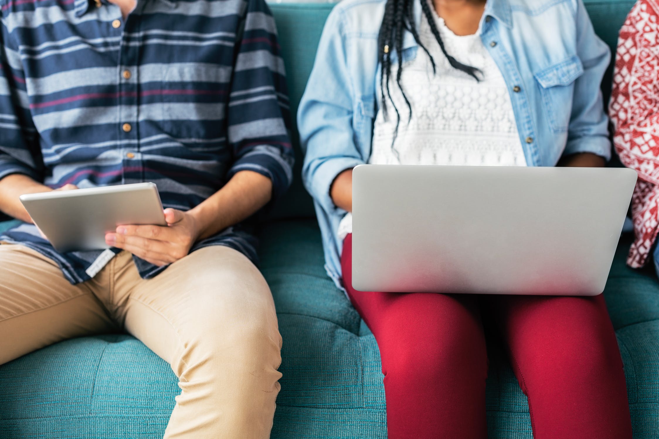 Image of two people sat next to each other using different digital devices