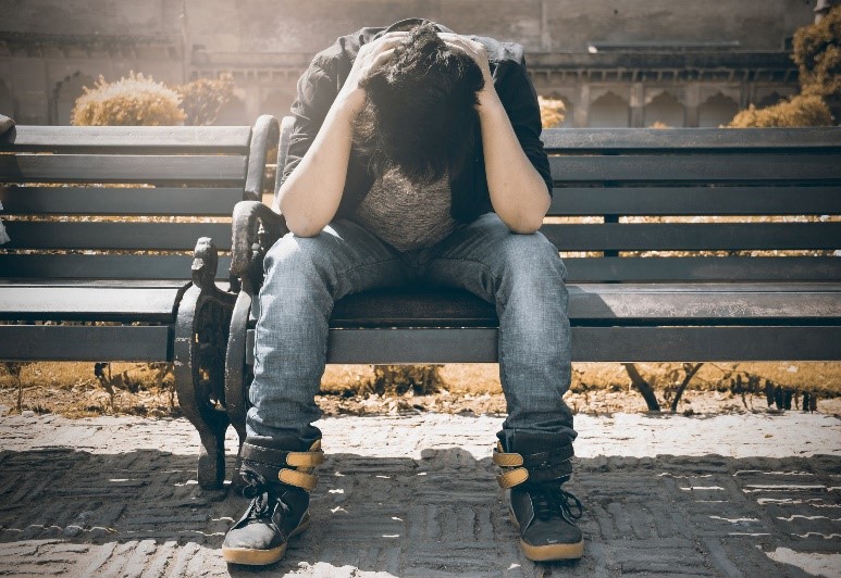 Person sitting with their head in their hands