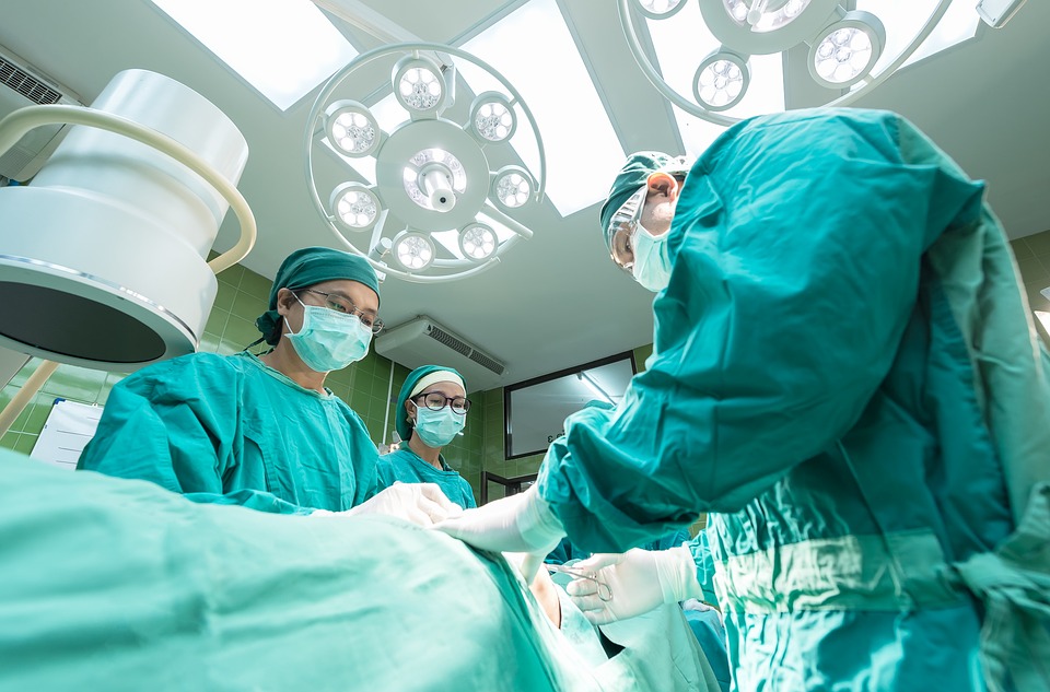 Three doctors performing surgery on a patient