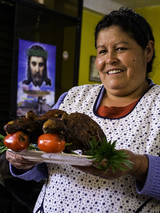 Woman serving cooked guinea pigs. 