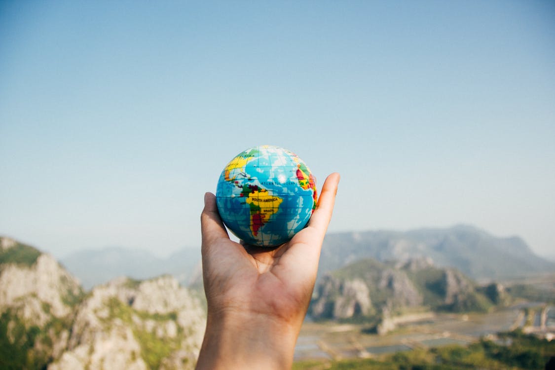 A model earth sitting in a person's hand 