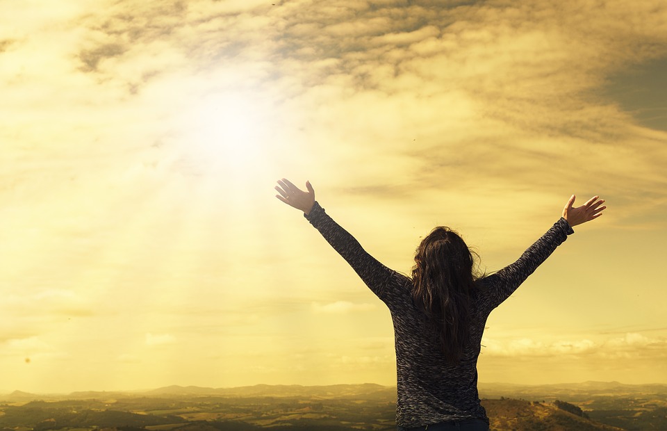 Woman with open arms looking towards the sky. 