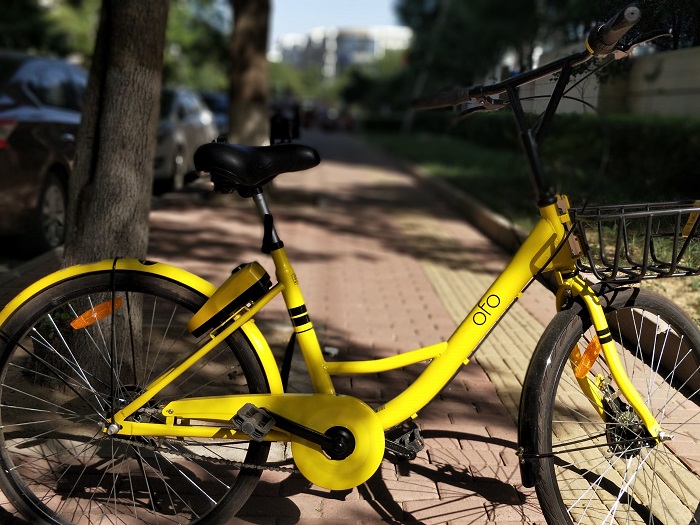 An Ofo bike share scheme bike is parked on a city street